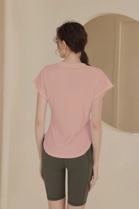 Detail view of pink moisture-wicking short sleeve gym shirt with curved hem and crew neck