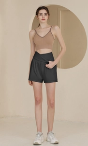 Détail du short de sport noir taille haute avec une ceinture croisée en forme de V unique