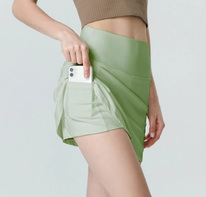 Detail view of avocado green sports skirt with high waist and side phone pocket