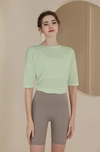 Detail view of a loose mint green sports t-shirt and grey cycling shorts set