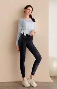 Détail du haut de yoga bleu clair avec découpe asymétrique et nœud sur le côté
