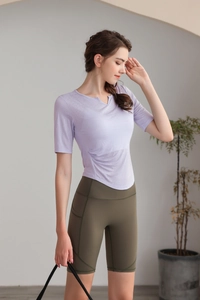 Détail du haut de yoga violet avec col en V et fronces élégantes à la taille latérale