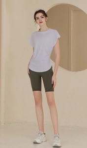 Detailed side view of loose flutter sleeve yoga shirt and high waist cycling shorts