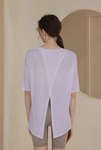 Back view of light purple yoga top with open cross design and sheer textured fabric