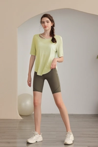 Detail of light green yoga top with asymmetric hollow cross neckline and biker shorts