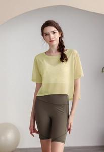 Dettaglio del top da yoga giallo ampio e dei pantaloncini da ciclista verde oliva
