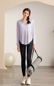 Détail d'un haut de yoga violet clair avec encolure croisée et legging tie-dye