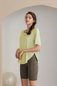 Detail of light green yoga top with side slits and olive green high waist shorts with pockets