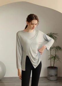 Détail de l'ourlet asymétrique et du tissu respirant de ce haut de yoga bleu pour femme