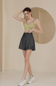 Detail der schwarzen Yoga-Shorts mit hoher Taille, Seitentasche und grünem Crop-Top