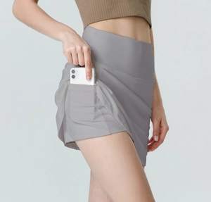 Detail of high-waisted grey sports skirt with side pocket holding a smartphone