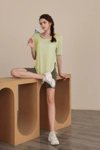 Detail of tencel yoga top with asymmetric hollow strap design and bike shorts