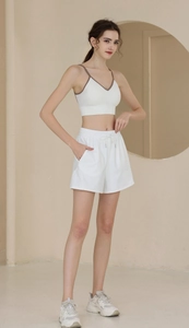 Detail of white nylon athletic shorts with elastic drawstring waist and side pockets