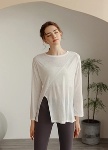 Détail du haut de yoga blanc à manches longues avec fente latérale et tissu tencel transparent