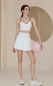 Dettaglio della gonna da tennis a vita alta e reggiseno sportivo bianco su modella
