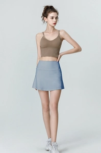Full-body shot of a high-waisted gray-blue tennis skirt with pockets and A-line silhouette