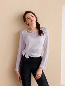 Détail du haut de yoga violet clair avec encolure découpée et nœud sur le côté de la taille