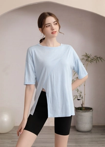 Détail du haut de yoga bleu clair avec fente latérale asymétrique et design d'ourlet