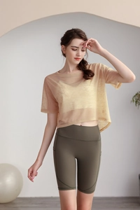 Dettaglio del top da yoga in rete gialla traspirante con pantaloncini verdi
