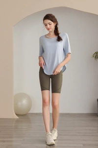 Detail of light blue short sleeve yoga top featuring stylish cut-out shoulder design