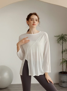 Détail d'un haut de yoga blanc en tencel avec fente latérale asymétrique fluide
