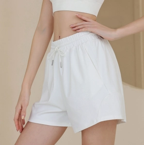 Detail of white high-waisted nylon sports shorts featuring elastic waistband and drawstring