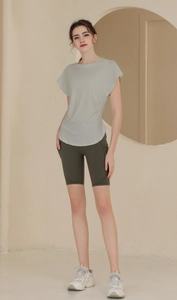 Close-up of women's sports set with gray-green t-shirt and dark green cycling shorts