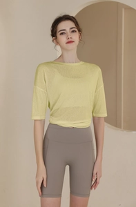 Detail of light yellow semi-transparent sports t-shirt with front twist knot design