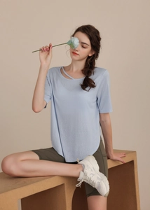 Detail of light blue yoga t-shirt featuring a stylish criss-cross neck strap design