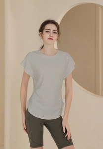 Detail of short-sleeve athletic top and green high-waist bike shorts with side pockets