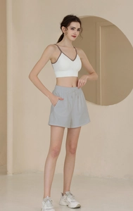 Close-up of high-waist drawstring sports shorts with side pockets and ribbed white sports bra