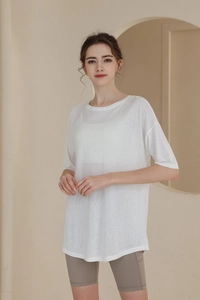 Detail of loose fit white sports t-shirt showing breathable fabric and draped design