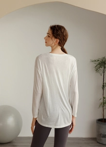 Vue arrière d'un haut de yoga blanc ample à manches longues en tissu tencel respirant