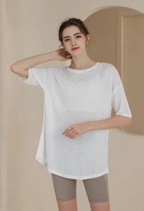 Detail of white loose-fit yoga top showing the lightweight breathable knit texture and fabric