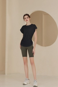 Detail of slim fit black sports tee and olive green cycling shorts with side pockets