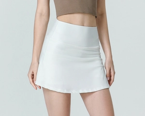 Detailed view of high-waisted white pleated tennis skirt showing stretch nylon fabric texture