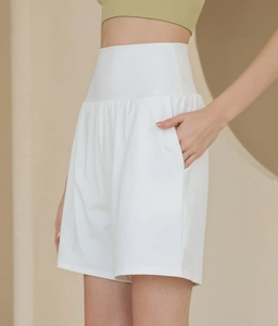 Detailansicht der weißen High-Waist Yoga-Shorts mit breitem Bund und Seitentaschen