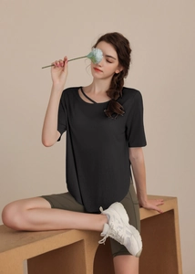Detail showing cross strap neckline and curved hem on black yoga t-shirt