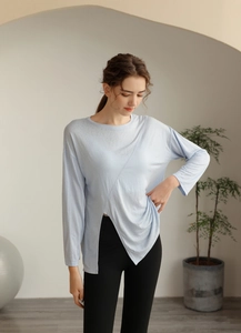 Détail du haut de yoga bleu clair à manches longues avec ourlet fendu asymétrique