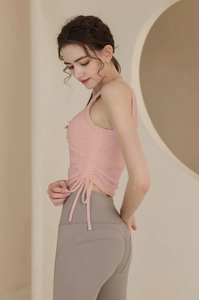 Détail du débardeur de yoga rose avec cordons de serrage latéraux et effet de fronces