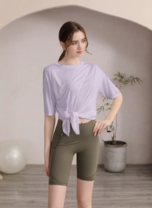 Détail du haut de yoga lavande avec nœud élégant et short de cyclisme vert pour femmes