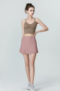 Detailed view of high-waist yoga skort with pockets and brown ribbed camisole top
