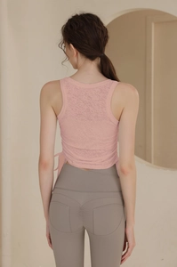 Détail du haut de yoga rose avec cordon latéral et legging avec plis à l'arrière