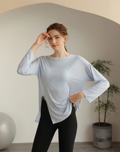 Détail du haut de yoga bleu clair avec ourlet fendu asymétrique et tissu respirant