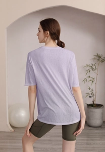 Vue de dos d'un t-shirt de yoga violet clair ample avec un short de cyclisme olive