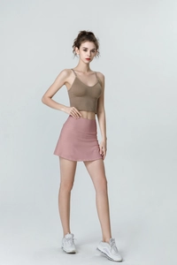 Detailed look of high-waisted pink sports skirt and brown crop top for yoga and fitness