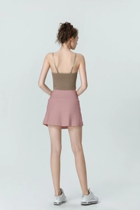 Rear view of high-waisted pink athletic skirt with built-in liner and brown ribbed top