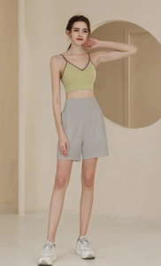 Detail der grauen High-Waist-Yogahose und des hellgrünen gerippten Sport-Tanktops