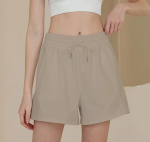 Detailed close-up of khaki nylon athletic shorts with high-waist drawstring and side stitching