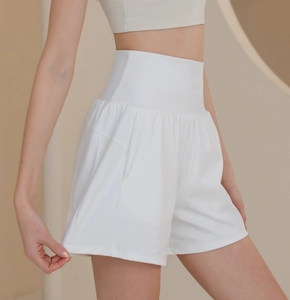 Detail view of white high-waisted nylon sports shorts with side pockets and elastic fabric